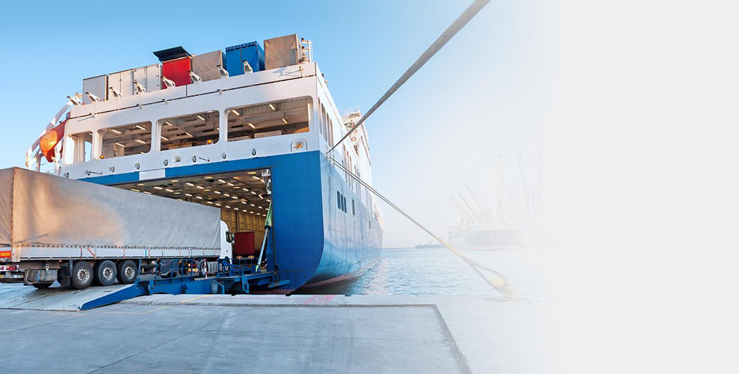 Land and sea communications connecting a cargo ship at a dock wtih a truck being loaded onto it